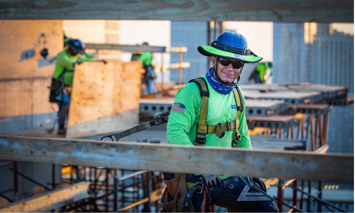 concrete construction worker harness clipped for safety