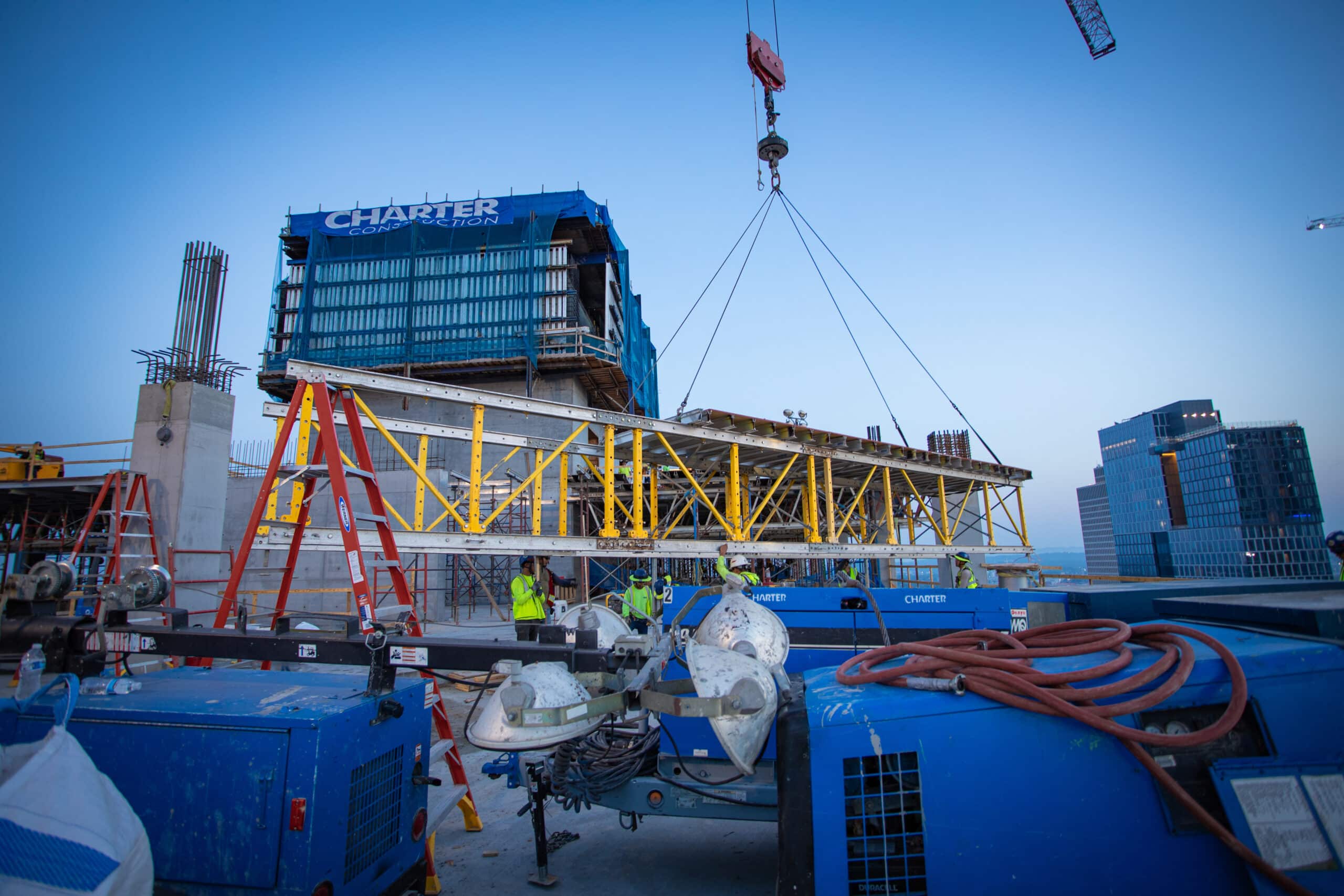 crane lowering beam on concrete construction project